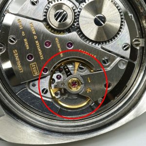 機械式時計のムーブメントの拡大画像です。テンプとアンクル・ガンギ車のいわゆる脱進機と呼ばれる部品がある箇所を赤丸で囲っています。