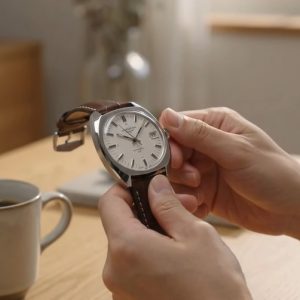 手巻き式時計のリューズを巻き上げる様子